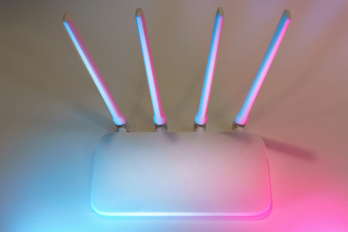 A wireless router illuminated in pink and blue