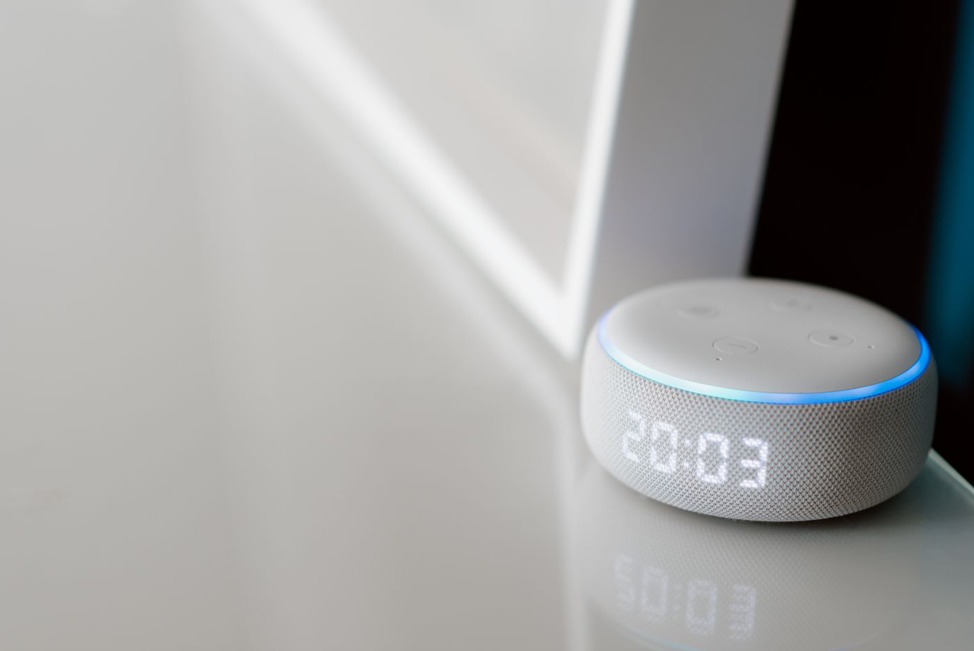 A compact smart speaker displaying the time