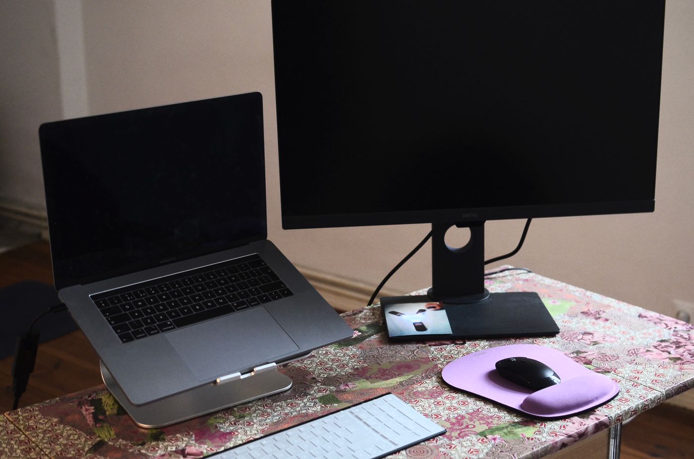 A laptop connected beside an external monitor on a desk