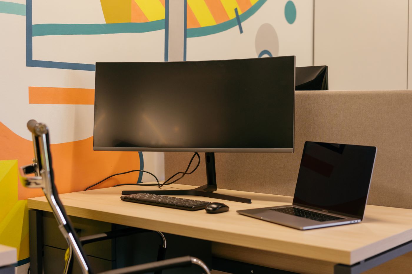 A monitor and laptop arranged on a corner desk