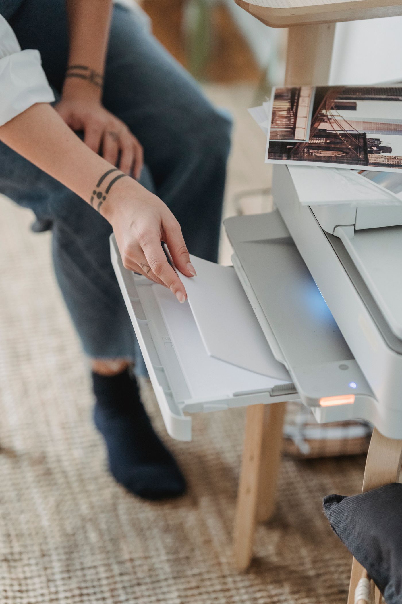 A person checking the paper tray of a home printer