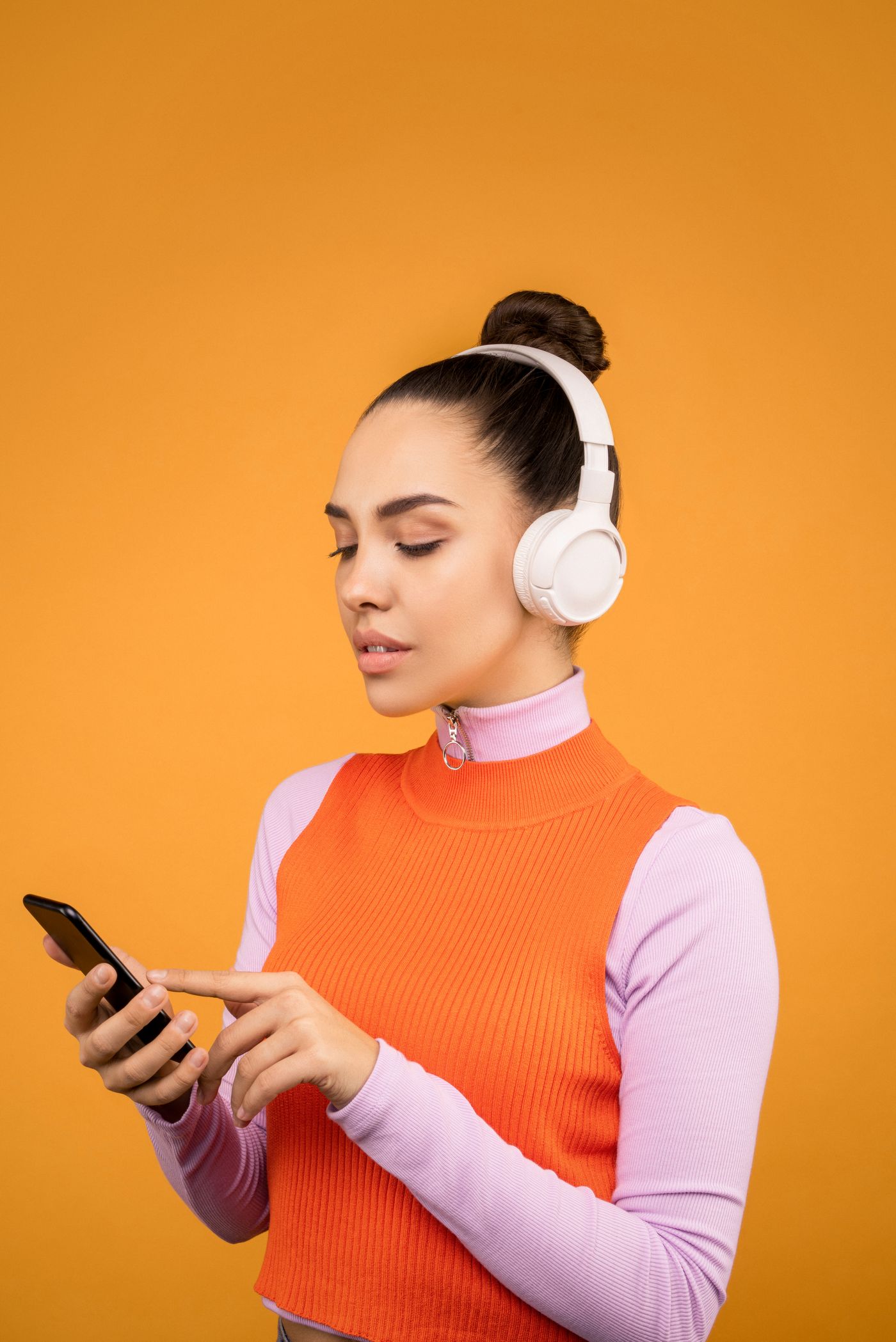 Person using a phone while wearing wireless headphones