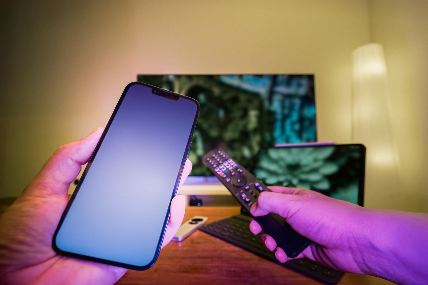Phone and remote control in front of a television