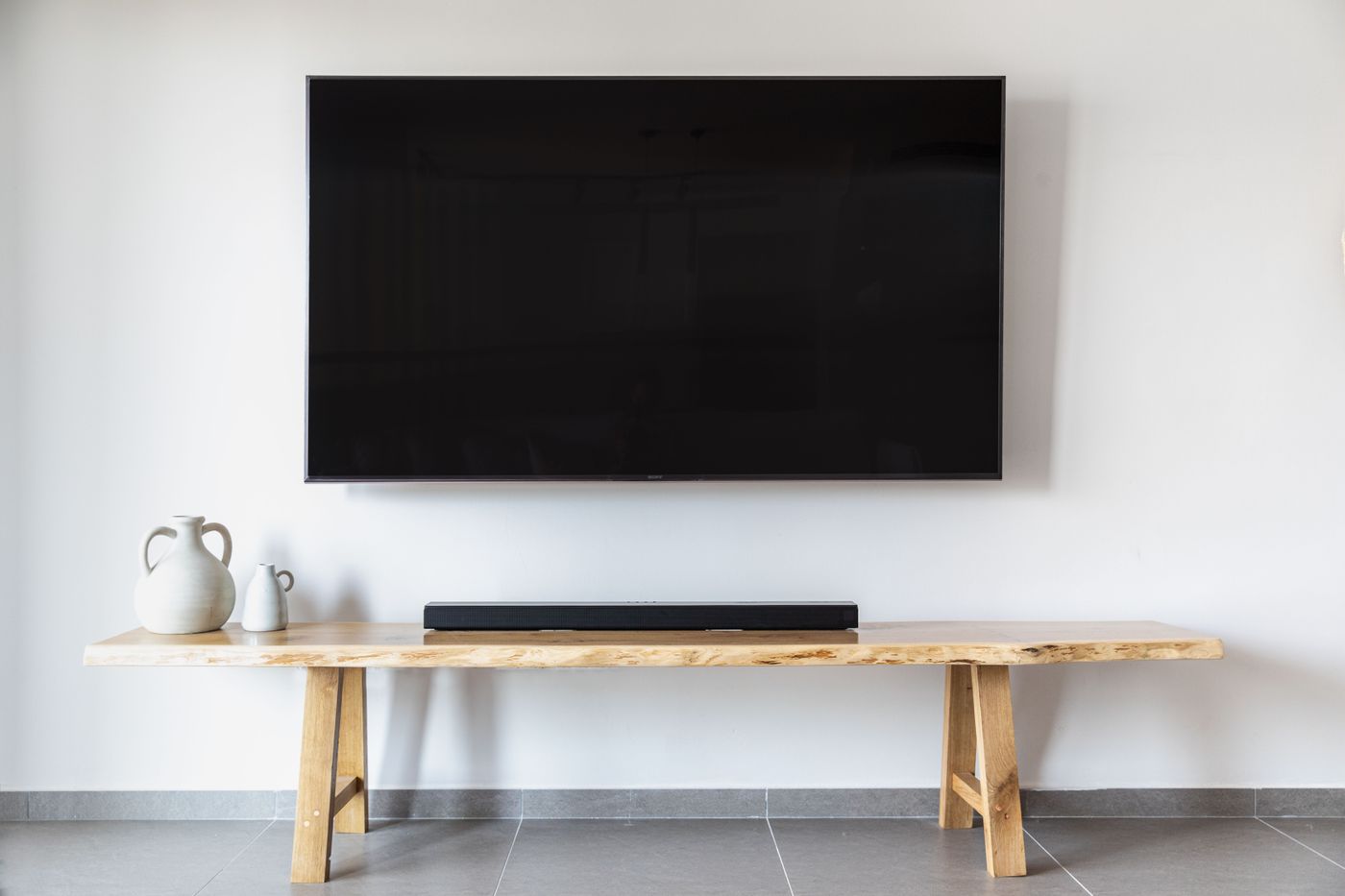 Television and soundbar above a wooden media console